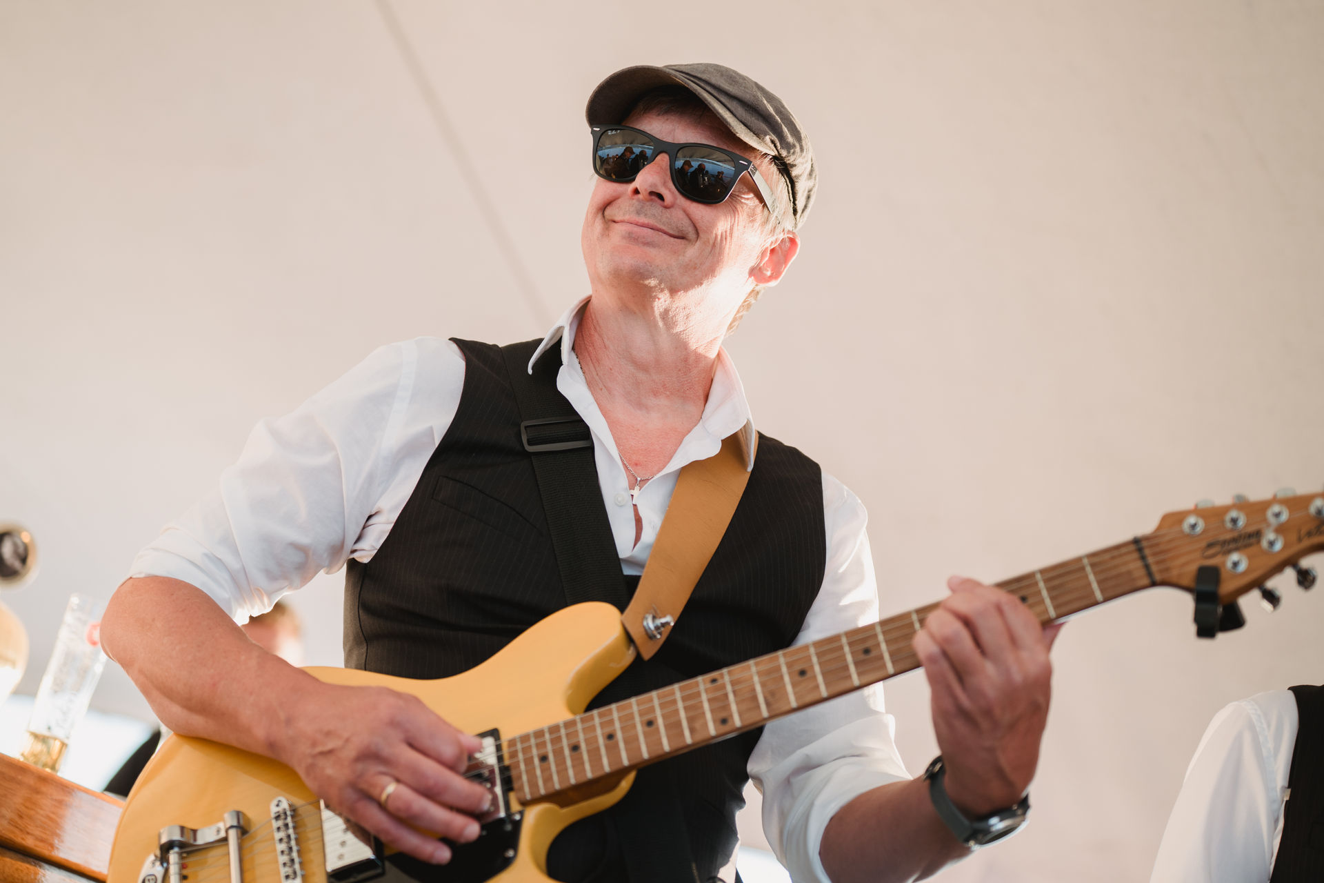 Gitarrist von The Swingbugs spielt lächelnd im Gegenlicht